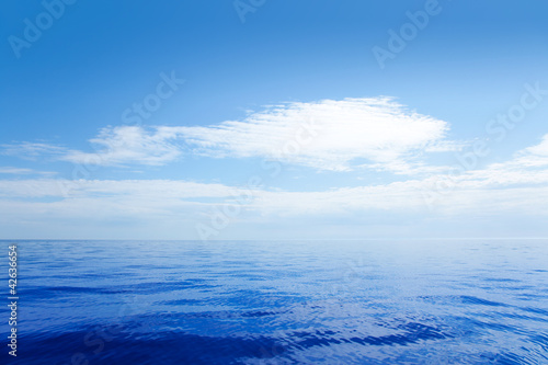 Blue calm sea water in with clouds mirror surface