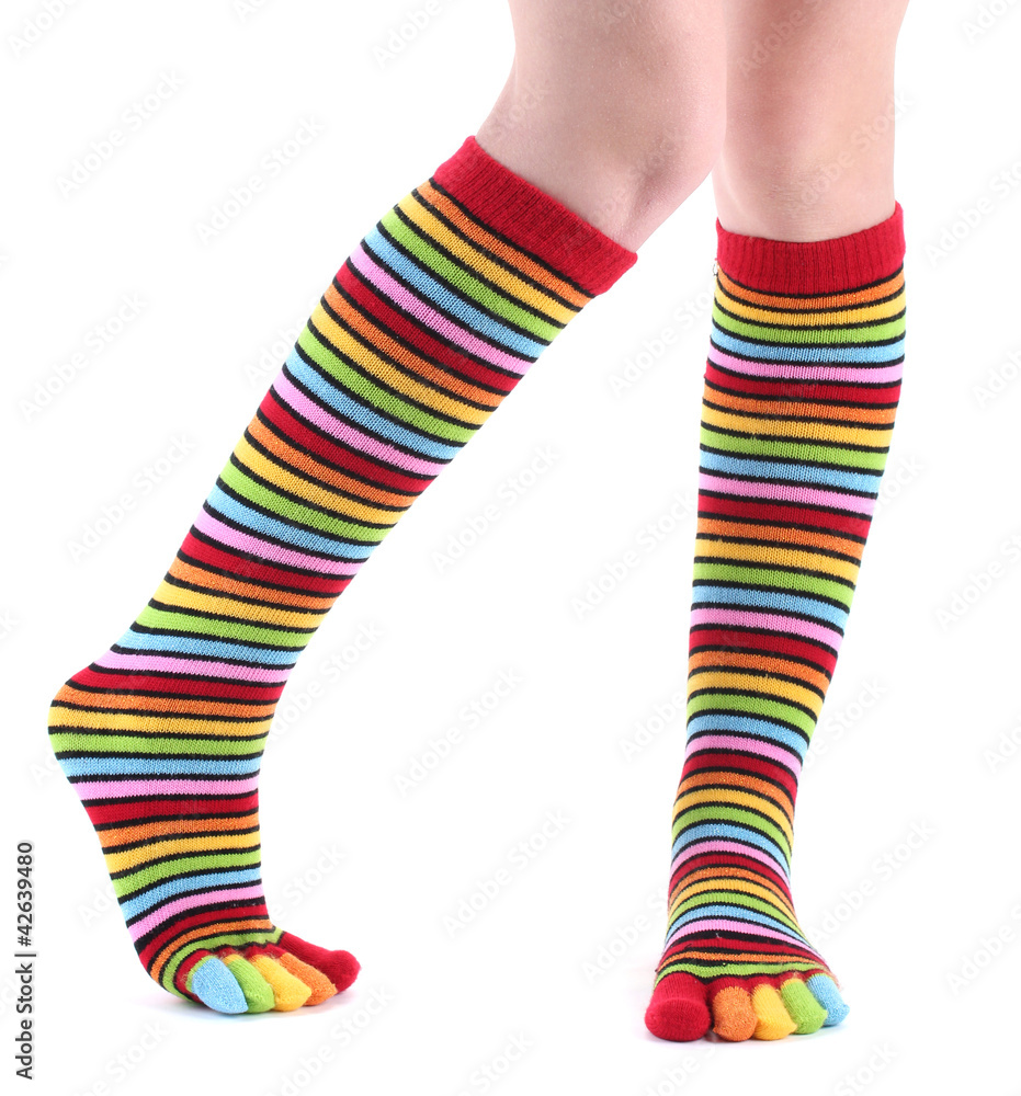 female legs in colorful striped socks isolated on white