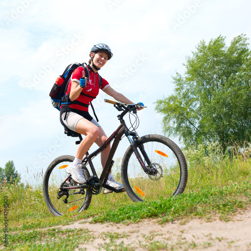 Happy Young Woman riding bicycle outside. Healthy Lifestyle
