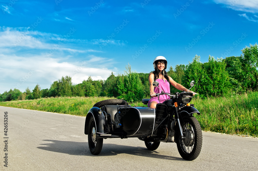 Fototapeta premium Pretty woman riding a motorcycle with a sidecar.
