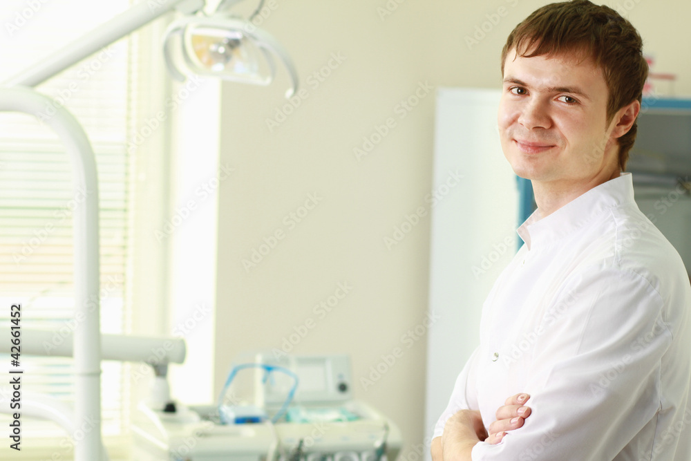 Man dentist at his office smiling Man dentist at his office smiling