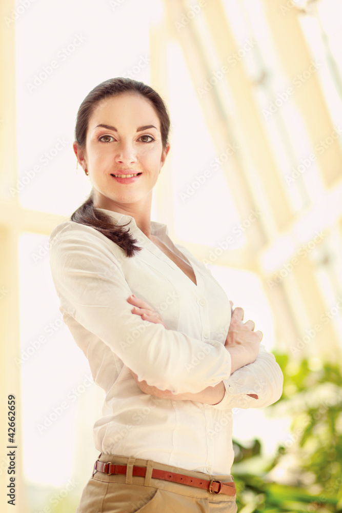Portrait of a beautiful young woman with folded arms