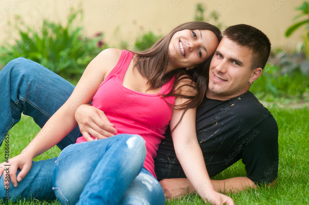 Beautiful young happy couple having fun in the grass Beautiful young happy couple having fun in the grass