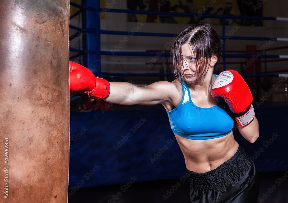 young and fit female fighter posing in combat poses