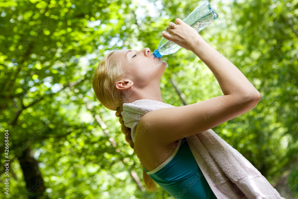 Portrait of beautiful smiling woman with bottle of water