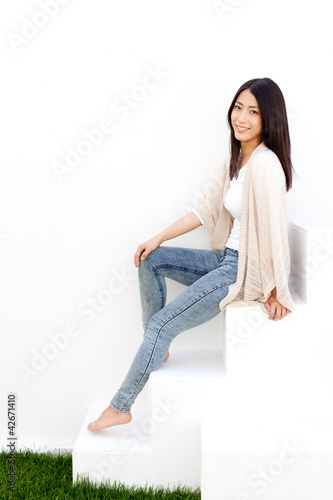attractive asian woman sitting on white stair