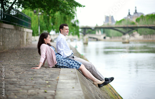 Joyful couple is sitting on the embankment