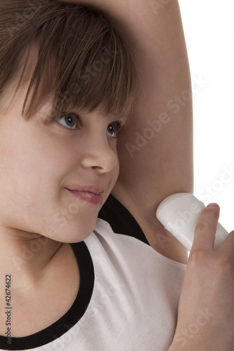 Girl applying deodorant on armpit