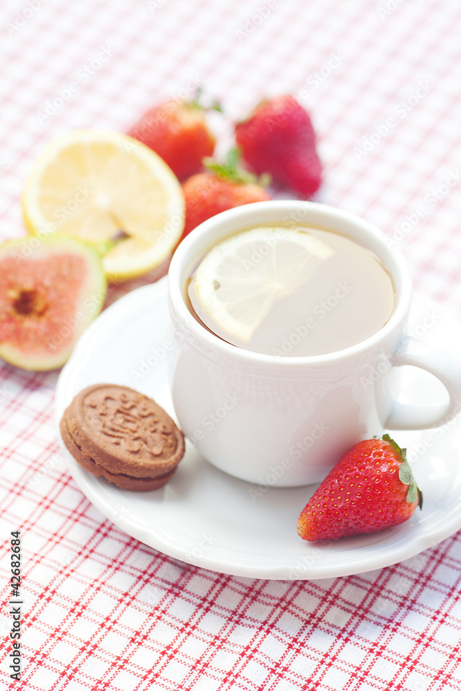 cup of tea,cookie, fig and strawberries on a plate cup of tea,cookie, fig and strawberries on a plate
