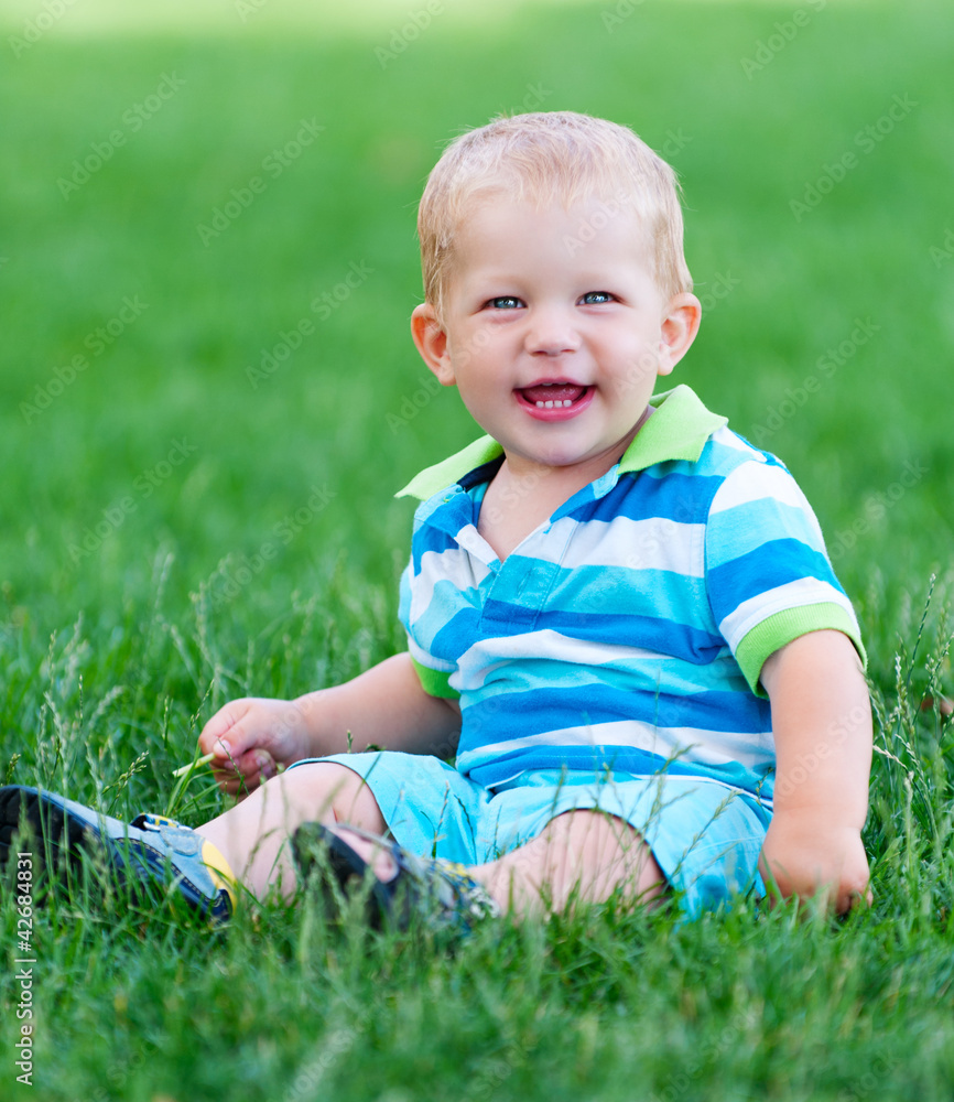 little boy sitting in green lawn little boy sitting in green lawn