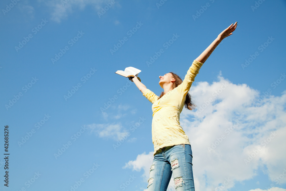 Young woman staying with raised hands