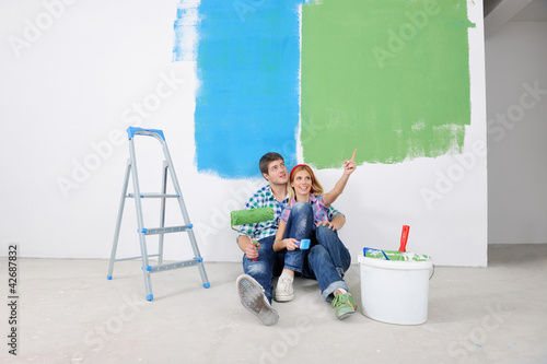 happy young cople relaxing after painting in new home photo