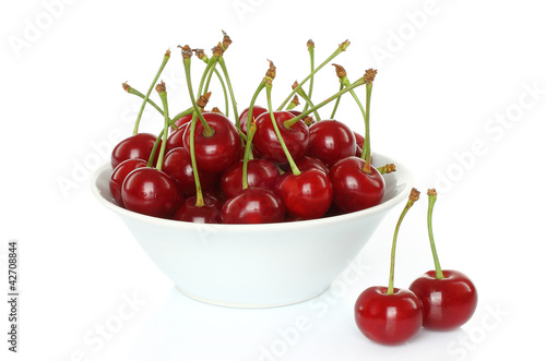 Bowl of sweet cherries on white background