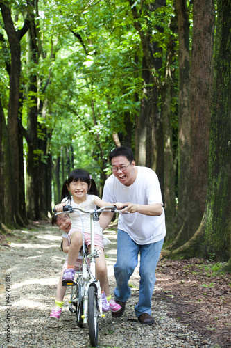 Father Teaching daughter to riding bicycle