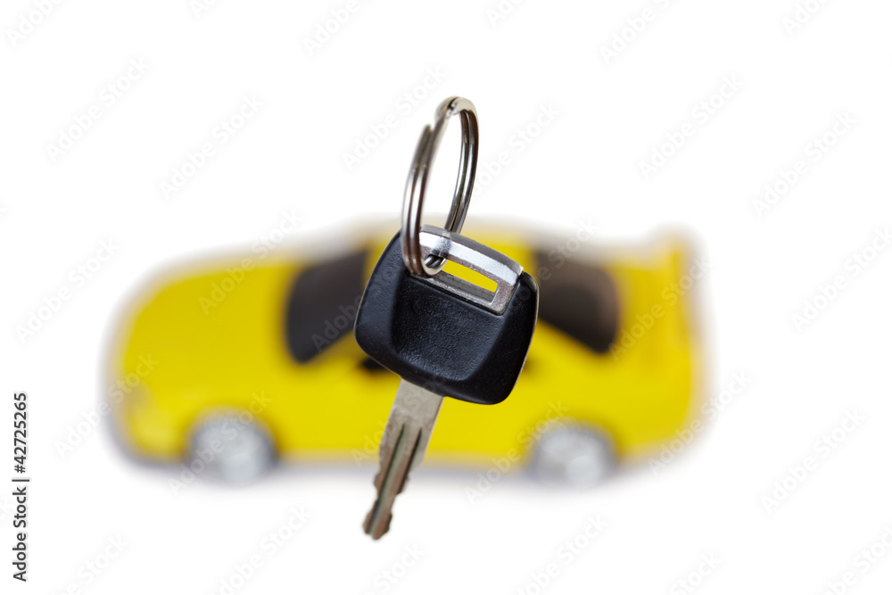 Key from car close up and yellow car in the background Key from car close up and yellow car in the background