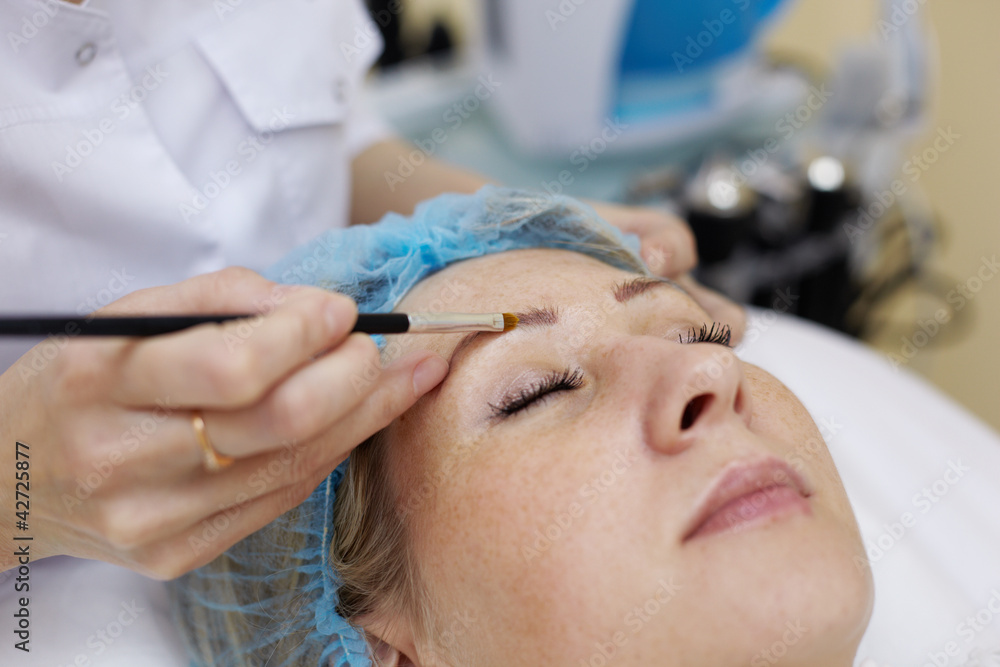 Hands of beautician that works with eyebrow of woman. Hands of beautician that works with eyebrow of woman.