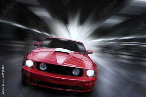 Luxury red sport car speeding in a underground parking