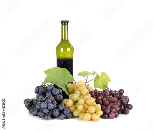 Fresh grapes with bottle of  wine isolated on white