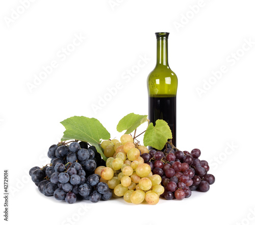 Fresh grapes with bottle of  wine isolated on white