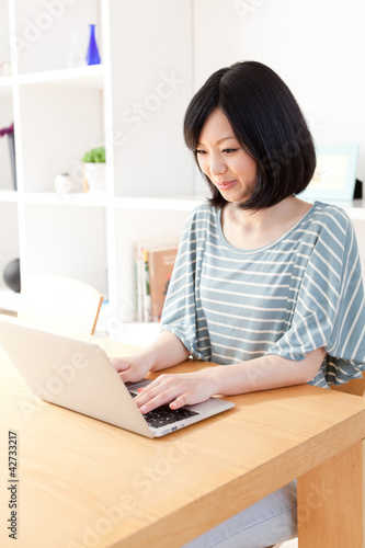 a young asian woman using laptop computer