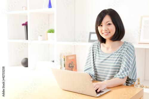 a young asian woman using laptop computer © taka