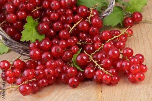 fresh red currants with leaves on.wood background
