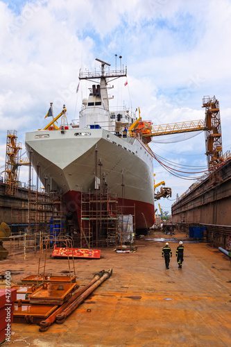 Fotografering A large cargo ship is being renovated in shipyard.