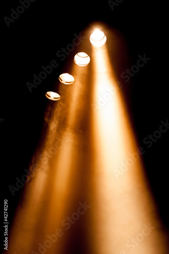 Four spotlights with orange beams
