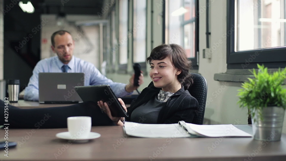 Happy businesswoman relaxing with tablet computer Happy businesswoman relaxing with tablet computer