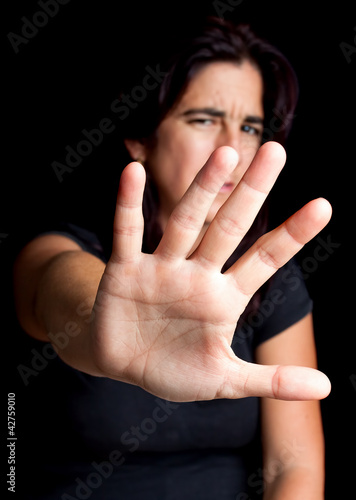 Frightened woman with her hand extended for protection