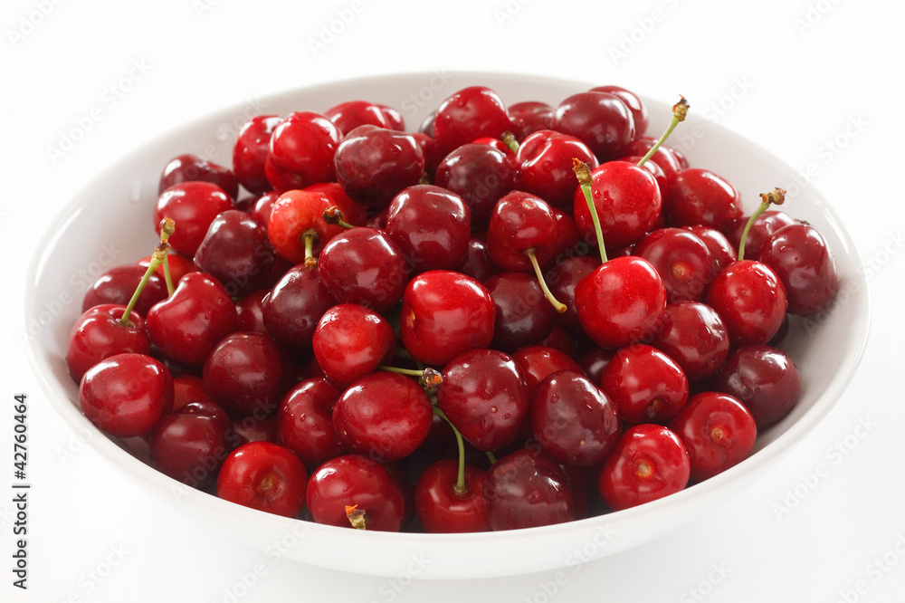 Ripe red cherries in a large white ceramic bowl Ripe red cherries in a large white ceramic bowl