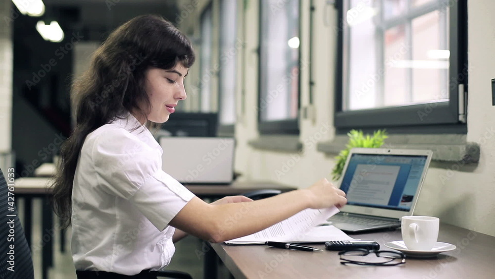 Attractive businesswoman signing documents in the office