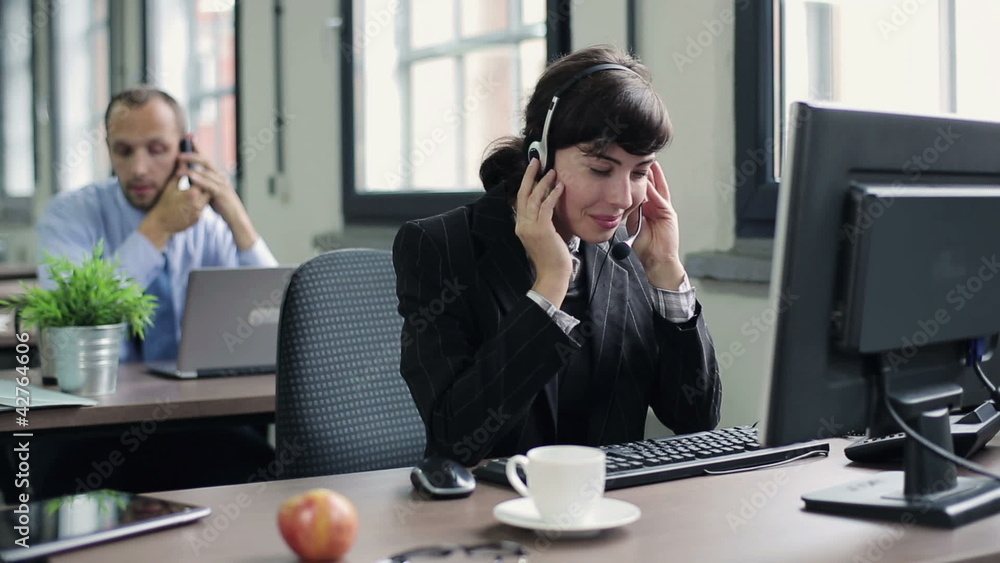 Friendly happy female helpdesk consultant in the office Friendly happy female helpdesk consultant in the office