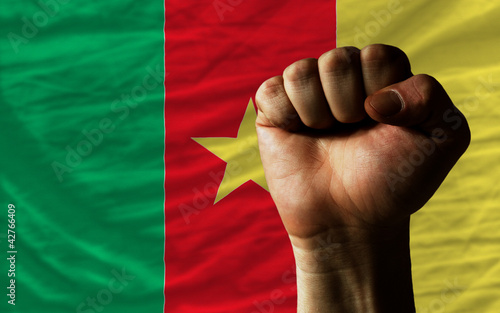 Hard fist in front of cameroon flag symbolizing power