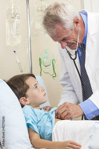 Senior Male Doctor Examining Young Boy Child Patient