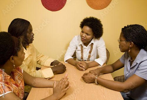 African women sitting at a table in discussion. photo