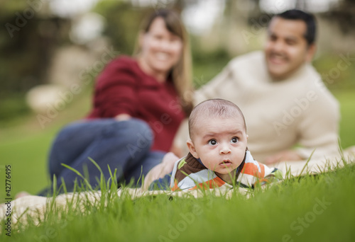 Happy Mixed Race Baby Boy and Parents Playing in Park