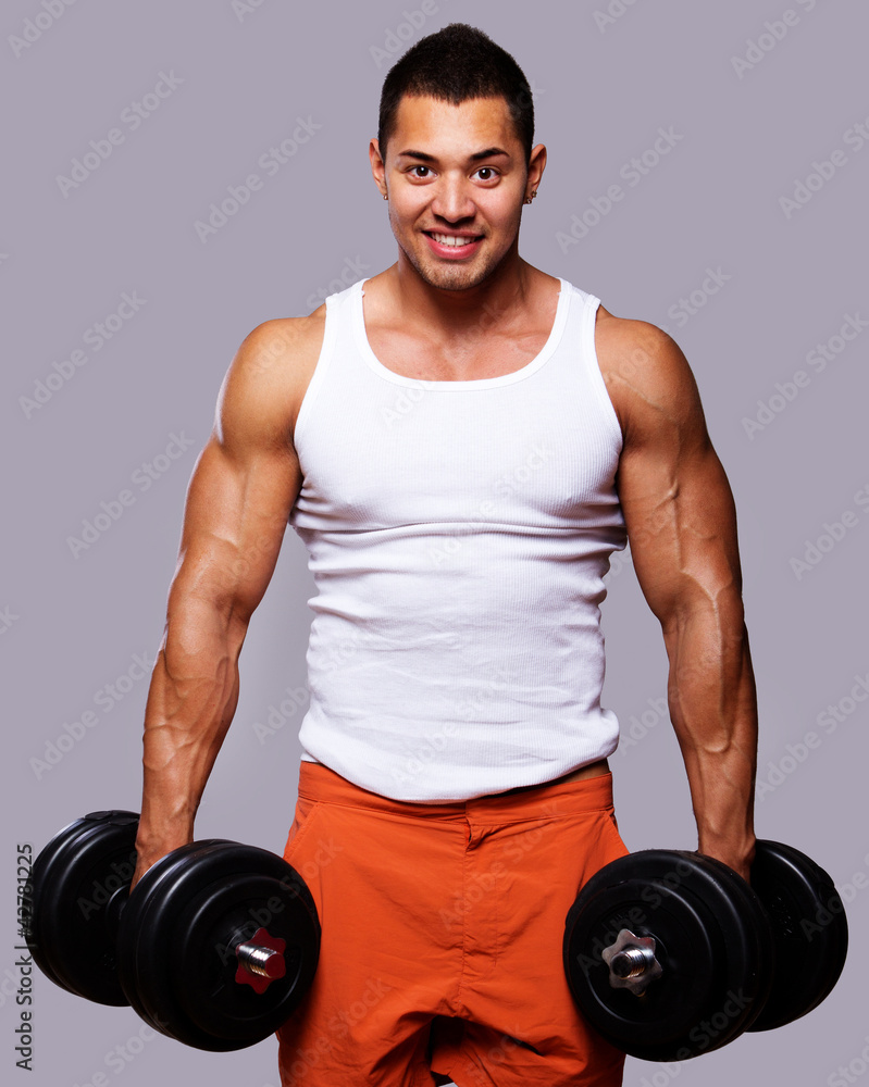 Fit muscular man exercising with dumbbells Fit muscular man exercising with dumbbells