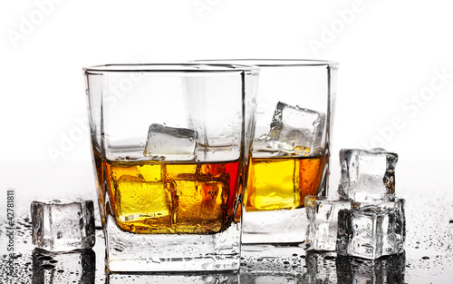 two glasses of scotch whiskey and ice on table isolated on