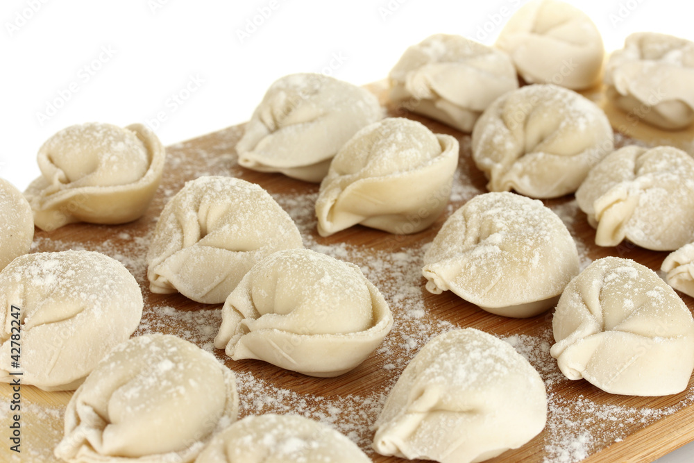 Raw Dumplings on cutting board on white background close-up Raw Dumplings on cutting board on white background close-up