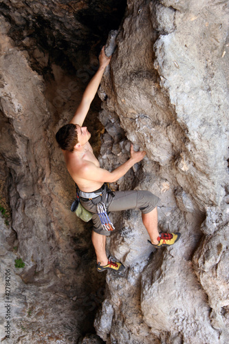 Rock climber climbing up a cliff.