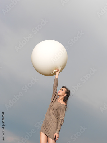 happy young woman jumping with balloon