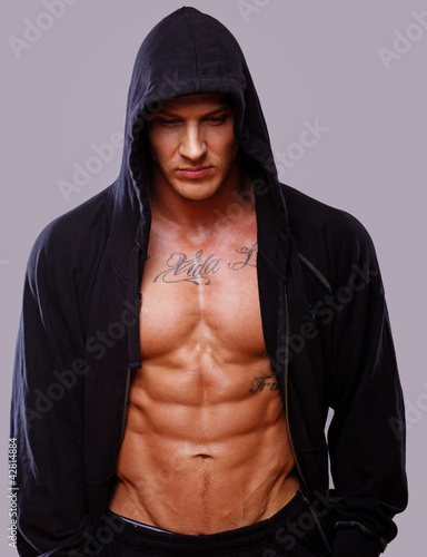 Portrait of muscle man posing in studio on grey background