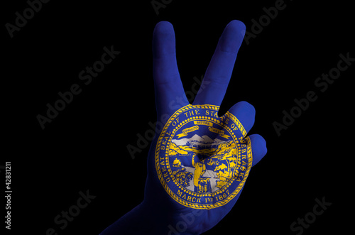 nebraska us state flag two finger up gesture for victory and win photo