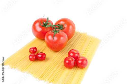 Raw spaghetti noodles and variety of ripe tomatoes