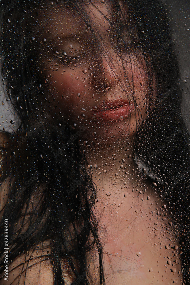 Naked girl in a wet glass on a black background