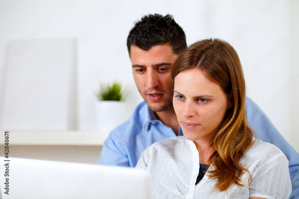 Attractive young couple using laptop together Attractive young couple using laptop together