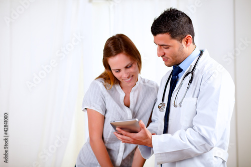 Handsome doctor and a female looking to tablet PC
