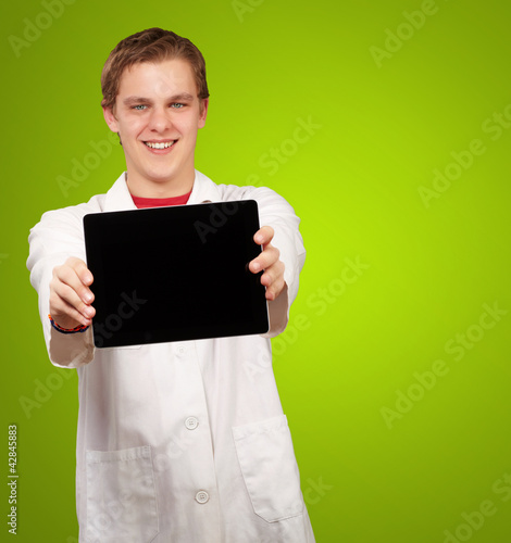 portrait of young man showing digital tablet over green backgrou