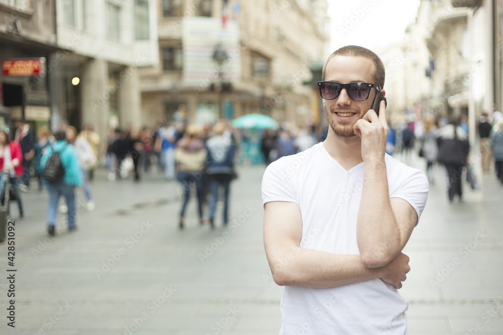 Fototapeta premium Man with sunglasses and cell phone walking